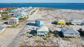 A coastal area with beachfront properties, including houses with balconies and a road running parallel to the beach. - Family Friendly with Gameroom! Outdoor swings and more! (Navarre)