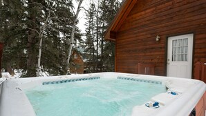 A hot tub in a wooden cabin surrounded by snow and trees. - 3-Level Spacious Cabin w/ Pool Table, Foosball, Close to Terry Peak & Skiing (Lead)