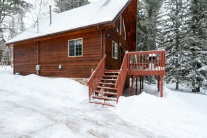 A wooden cabin with a wooden staircase leading to a porch. - 3-Level Spacious Cabin w/ Pool Table, Foosball, Close to Terry Peak & Skiing (Lead)