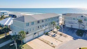 A coastal residential area with multi-story buildings, a beach, and a clear view of the ocean.