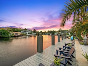 A waterfront property with a dock, wooden benches, and a view of the water.