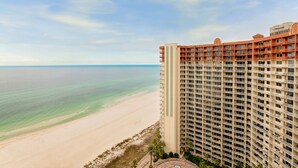 A high-rise hotel with multiple balconies overlooking a beach. - Beach Front Free round of Golf & Activities Daily! (Panama City Beach)