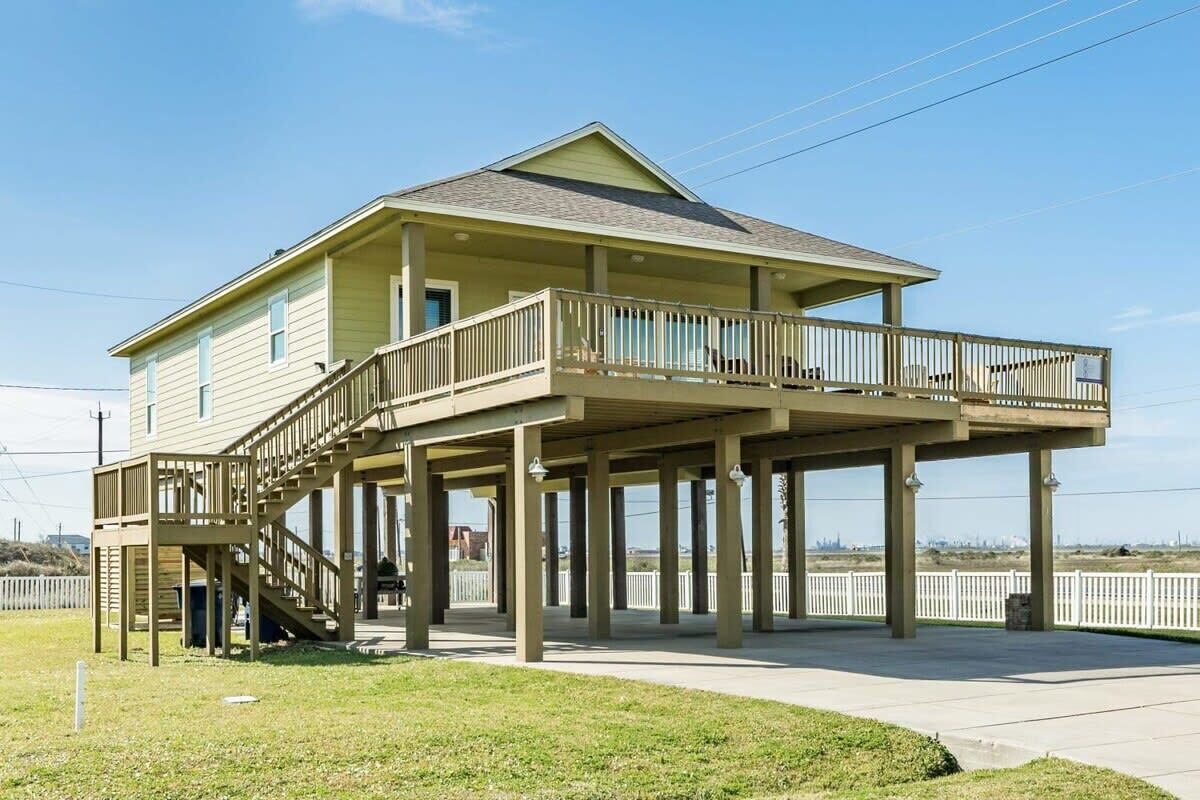 A two-story house with a balcony and a covered porch.