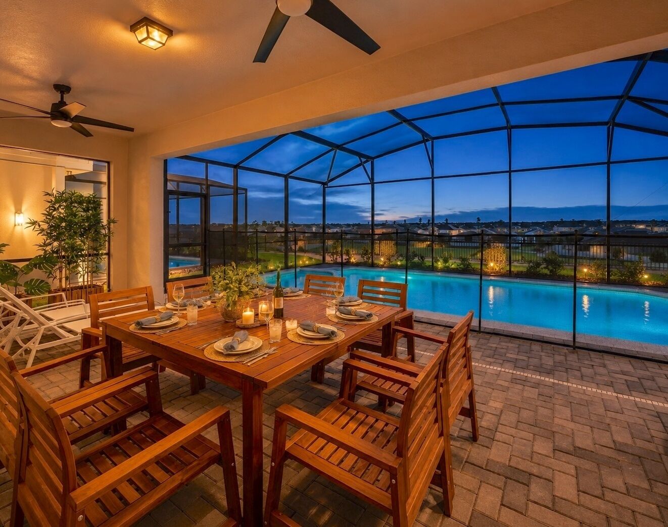 An outdoor dining area with a view of a swimming pool at dusk.