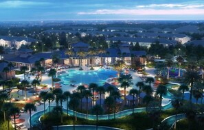 Relax by the resort's central pool surrounded by palm trees and lounge areas.