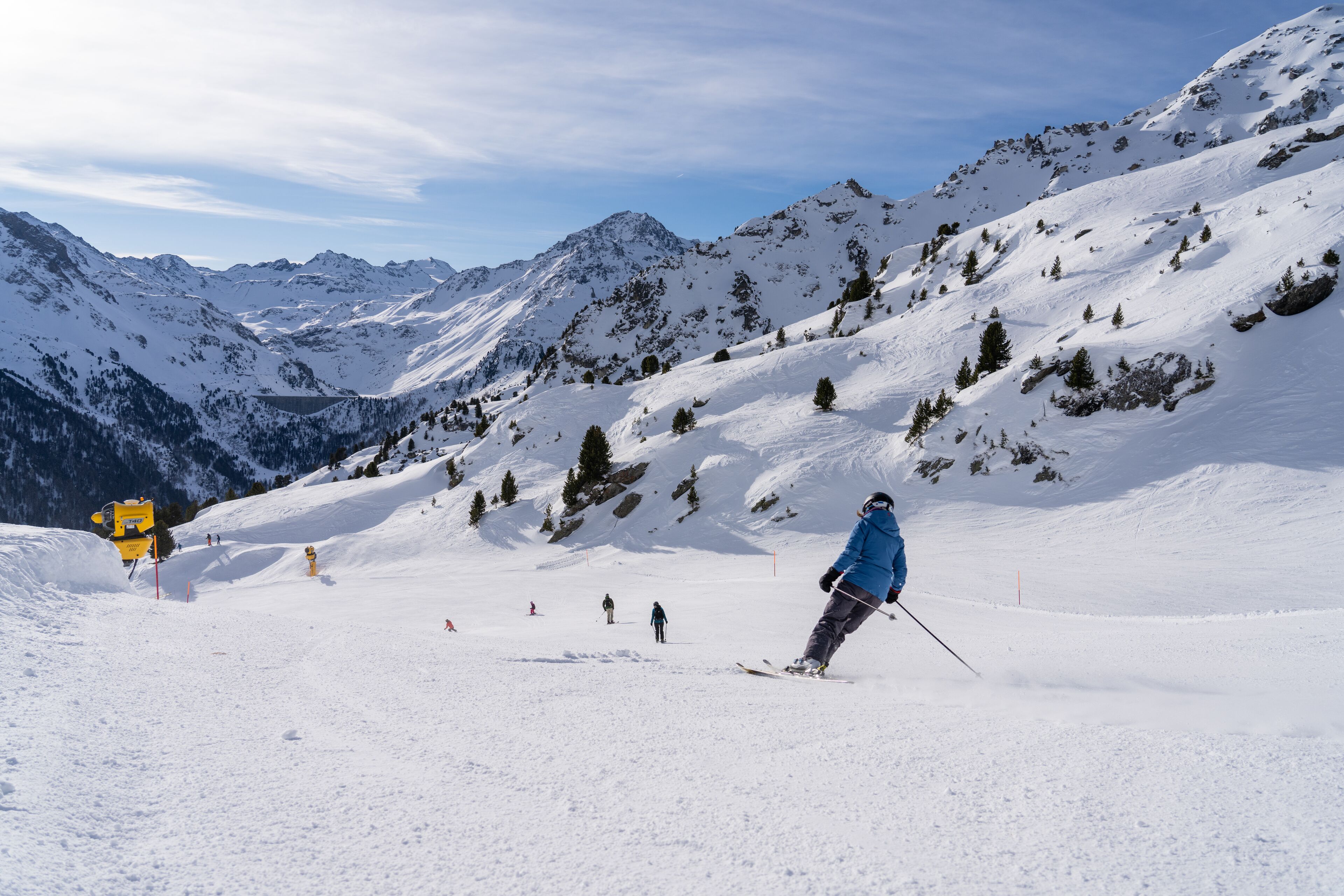 A snowy mountain landscape with skiers.