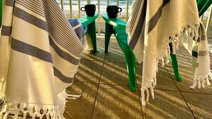 A balcony with striped blankets and green chairs, overlooking the sea. - BOOK NOW for a Great GetAway~2 Bedroom/ 3 Bath~Gulf Front!!!! (Gulf Shores)