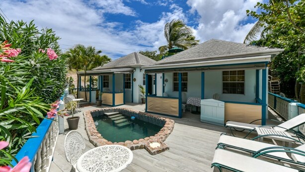 Un espace aménagé au bord de la piscine, comprenant une petite piscine, des chaises longues et un coin salon abrité.