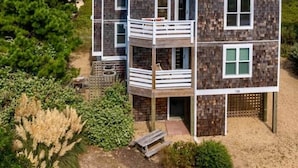 Ein zweistöckiges Haus mit Balkon in Strandnähe.