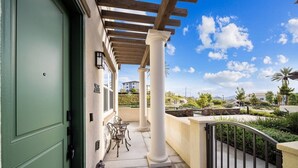 A covered outdoor area with a pergola, columns, and a view of a landscaped area with trees and a distant building. - Luxe Private Getaway in the Heart of Oceanside! (Oceanside)
