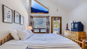 A bedroom with a large bed, a dresser, a television, and a window with curtains. - Pinecreek #G- 3 BR: Close to Town- Shuttle to Slopes- Pool & Hot Tub Access (Breckenridge)