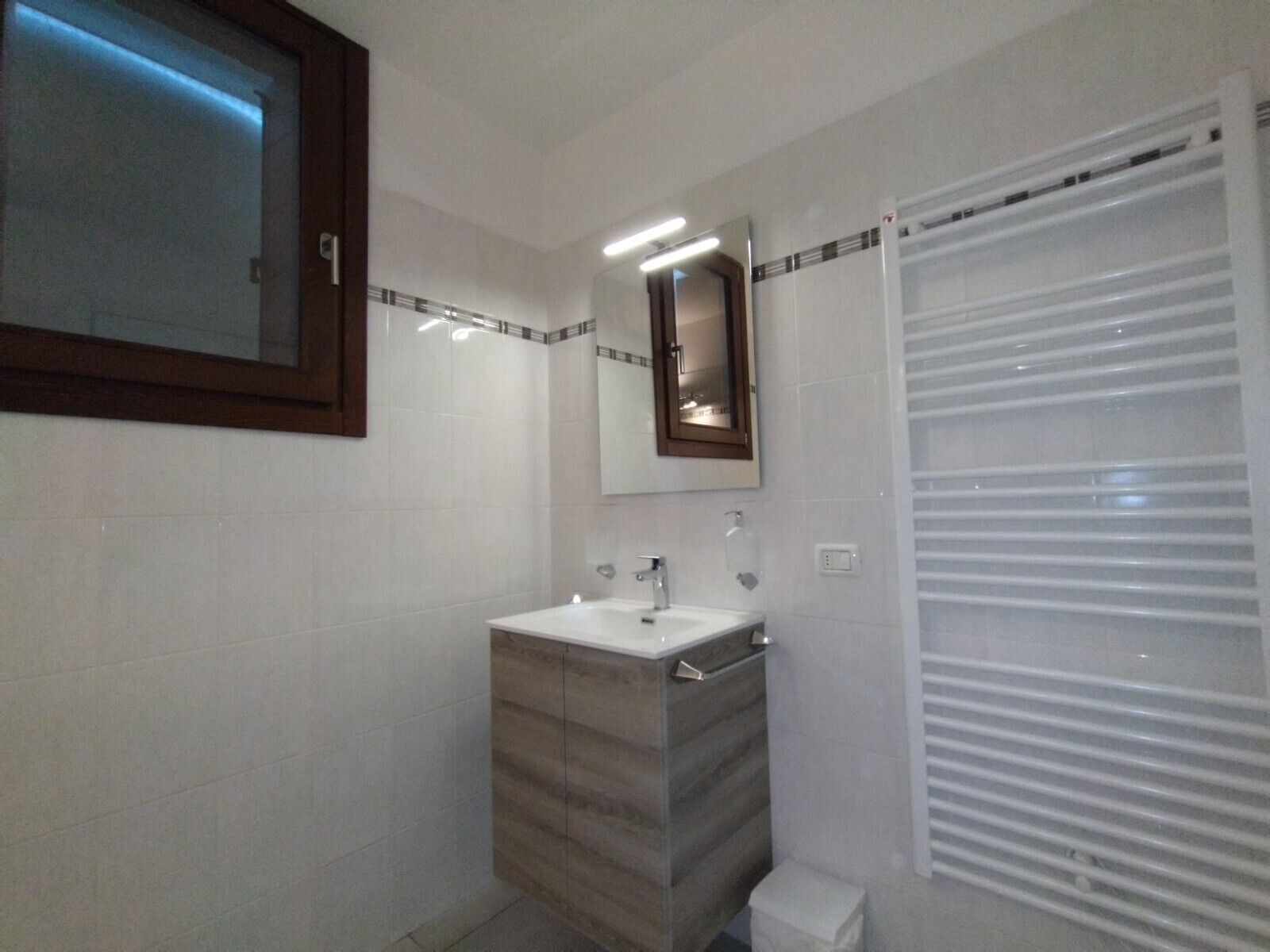 Une salle de bain avec un lavabo, un miroir et une douche.