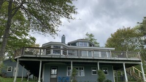 Ein großes, zweistöckiges Haus mit Balkon und überdachter Veranda.