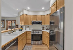 Enjoy cooking in this well-equipped kitchen with a refrigerator, oven, and microwave, offering a view of the city.