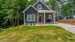 A two-story house with a porch, a front door, and a small front yard. - Beautiful cottage with AMAZING view of Barren River Lake! (Scottsville)