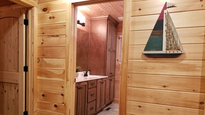 A wooden interior with a kitchen area featuring cabinets and a small sink. - Beautiful cottage with AMAZING view of Barren River Lake! (Scottsville)