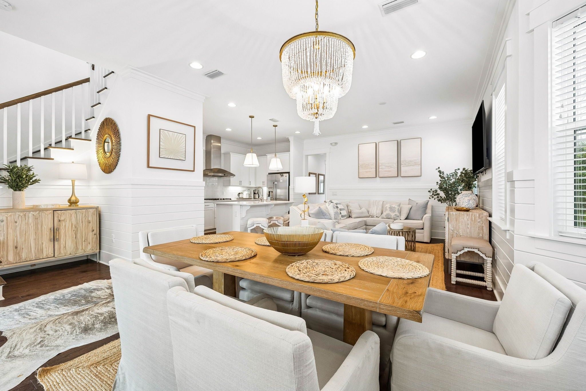 A modern interior with a dining area, a sofa set, and a kitchen.