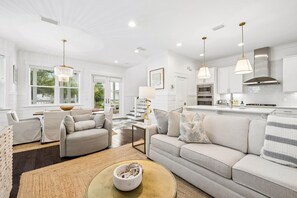 A modern living room with a sofa, armchairs, and a coffee table.