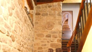 Uma escadaria de pedra com degraus e corrimão de madeira.