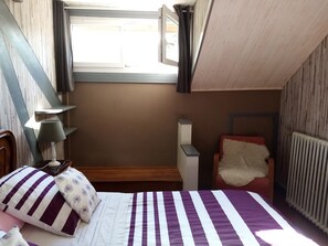 A bedroom with a bed, a nightstand, a lamp, a chair, and a window. - INDEPENDENT APARTMENT in Garennes s/Eure at HAVRE DE PAIX - 3/4 pers (Neuilly)