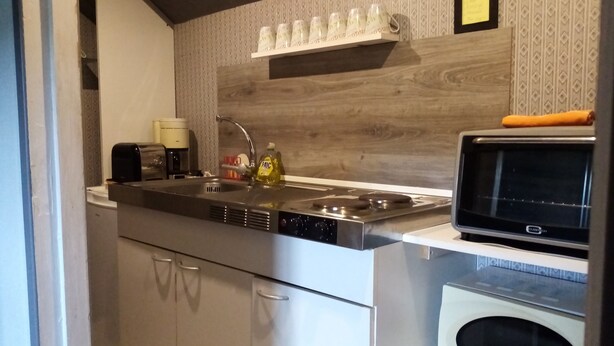A compact kitchen with a stainless steel sink, a microwave, and a built-in oven. - Waterfront Apartment in Garennes-sur-Eure at Le Havre de Paix - Sleeps 3–4  (Neuilly)