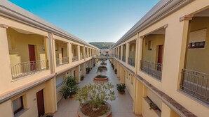 A multi-level building with balconies and potted plants. - Appartamenti Le Fontane con piscina (Villasimius)