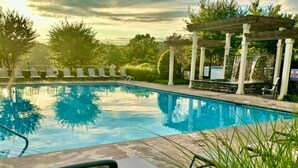 Une piscine avec des chaises longues et une pergola.