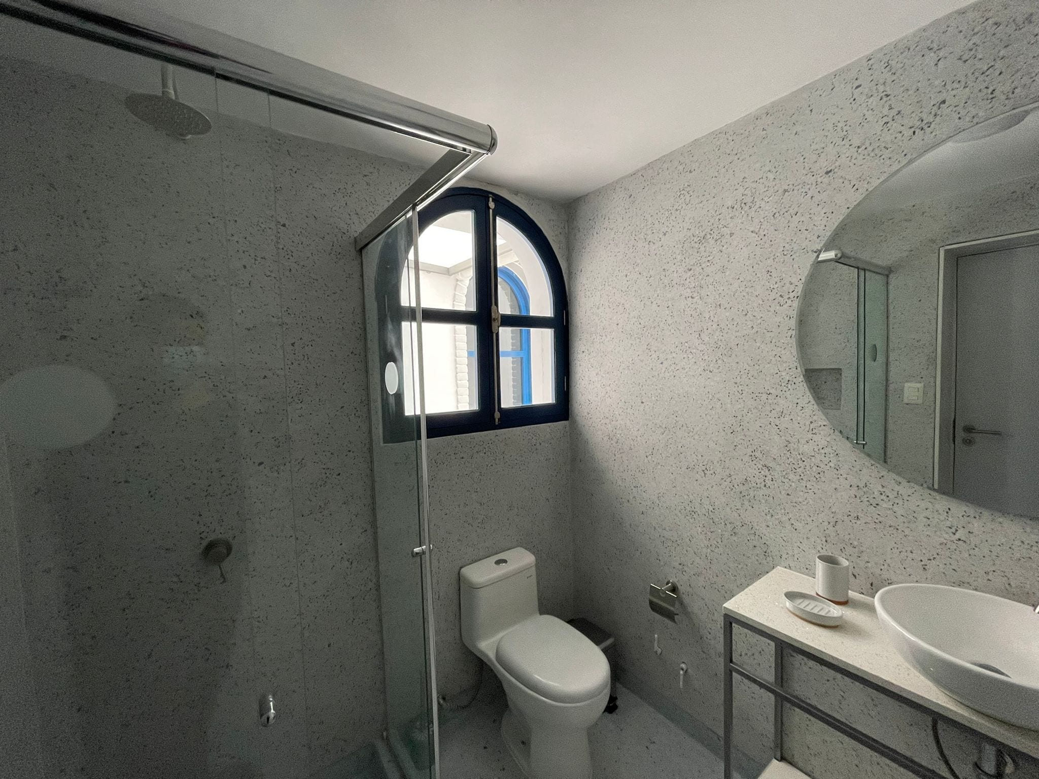 A bathroom with a shower, toilet, and sink.