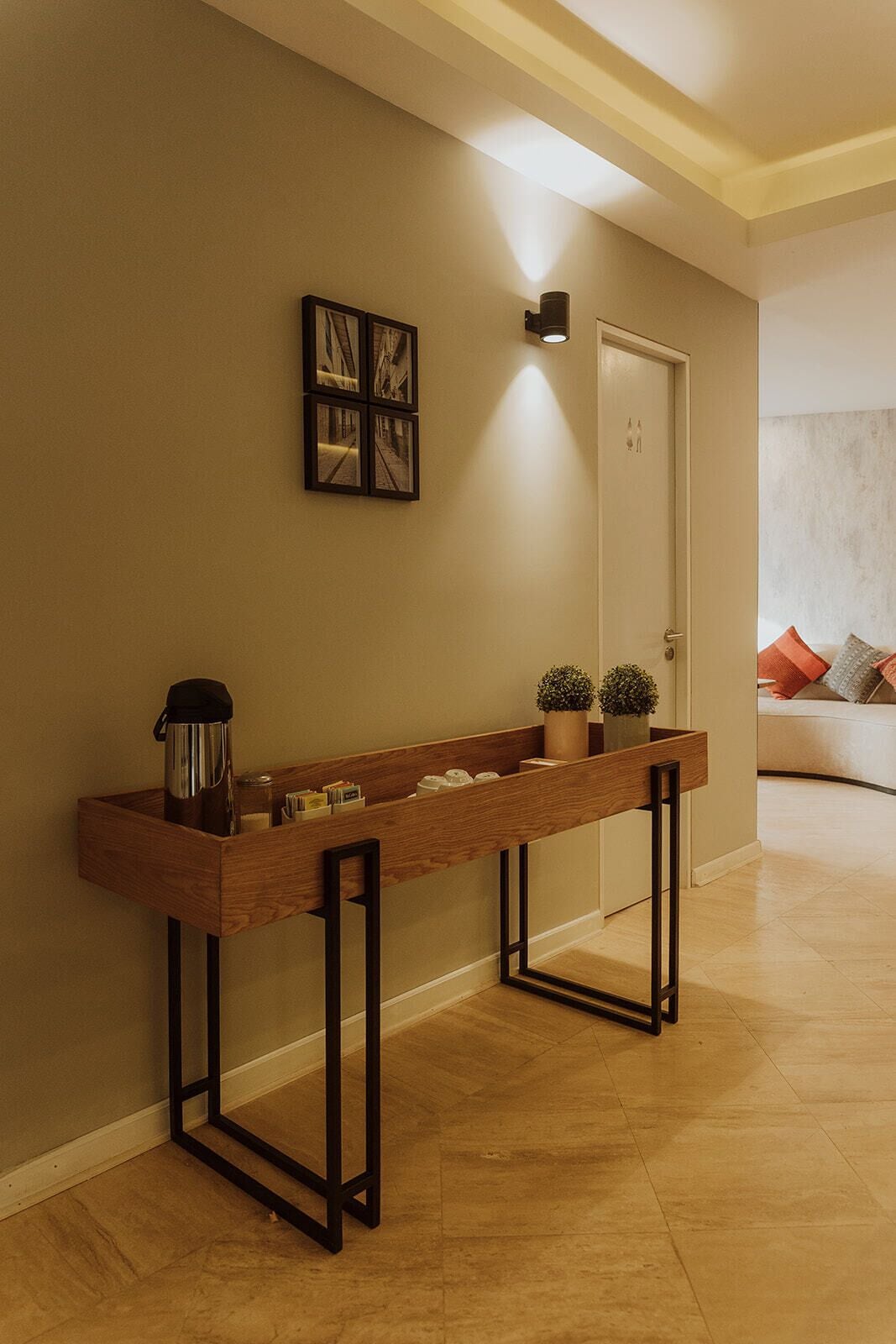 A hallway with a wooden console table, a door, and a framed picture on the wall.