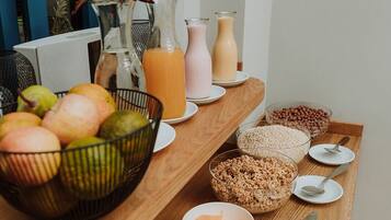 A breakfast buffet with various fruits, cereals, and beverages.