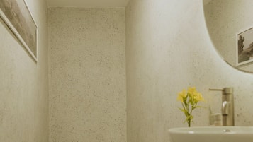 Un baño con inodoro, lavamanos y espejo.