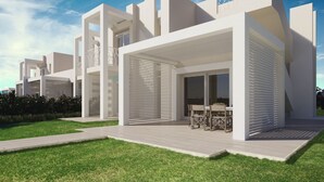 A modern residential building with a covered patio area and a lawn. - Capo Falcone Charming Apartments (Stintino)