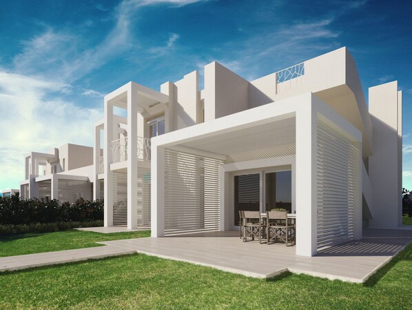A modern residential building with a covered patio area and a lawn. - Capo Falcone Charming Apartments (Stintino)