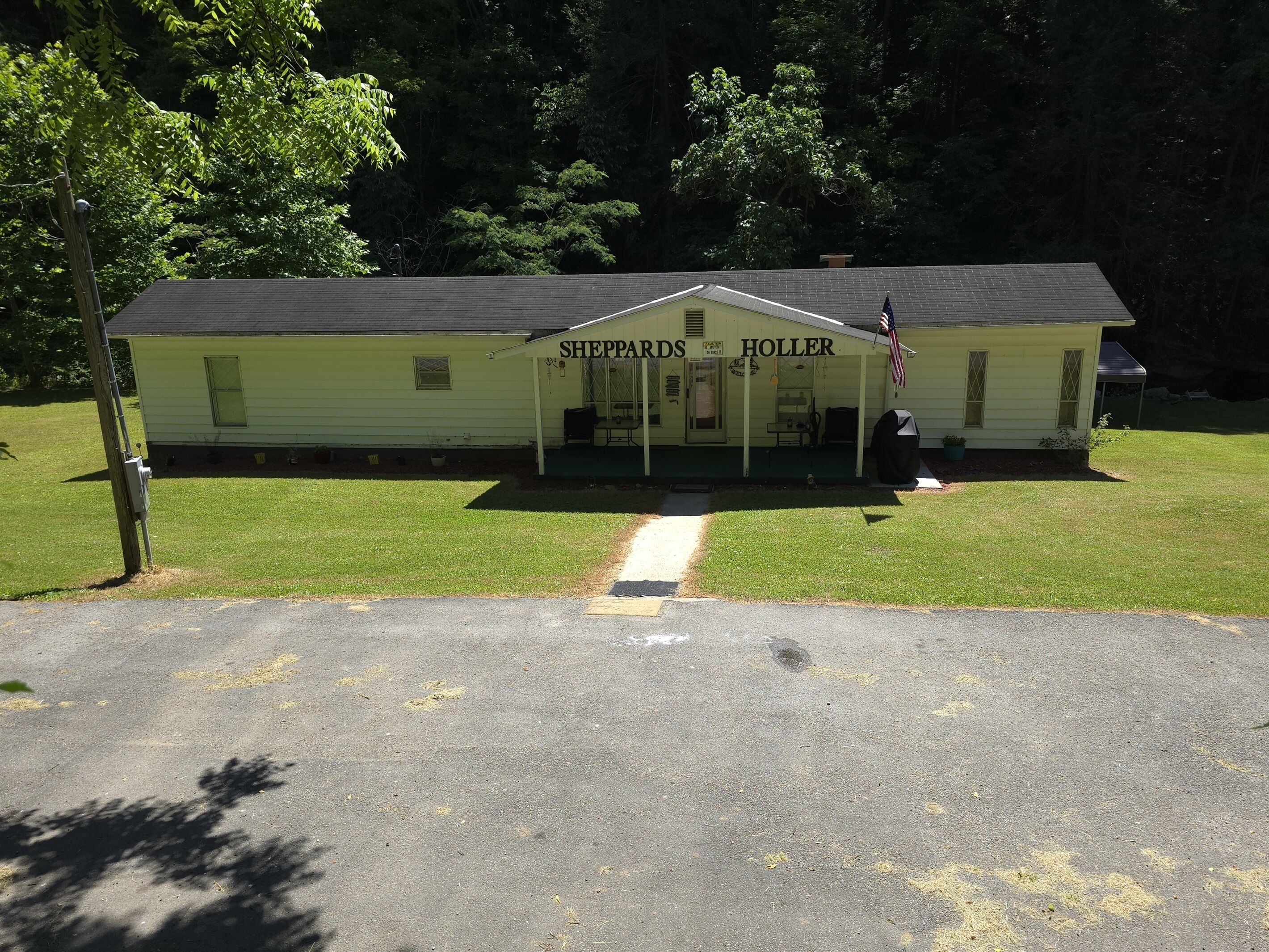 A two-story building with a sign reading "Sheppards Holler."