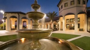 A fountain in a courtyard with a building in the background.
