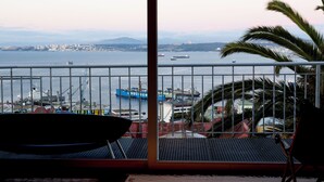 A balcony with a view of a harbor, including ships and a distant cityscape. - Casablu Hotel (Valparaiso)