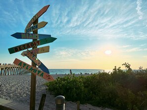 A wooden signpost with directional arrows pointing to various cities. - The happy family Hideaway (Port Charlotte)