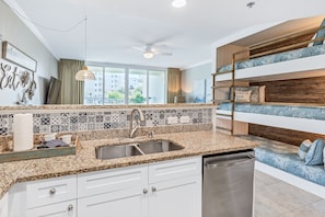 Enjoy cooking in this well-equipped kitchen with a sink, stainless steel appliances, and a window offering a view.
