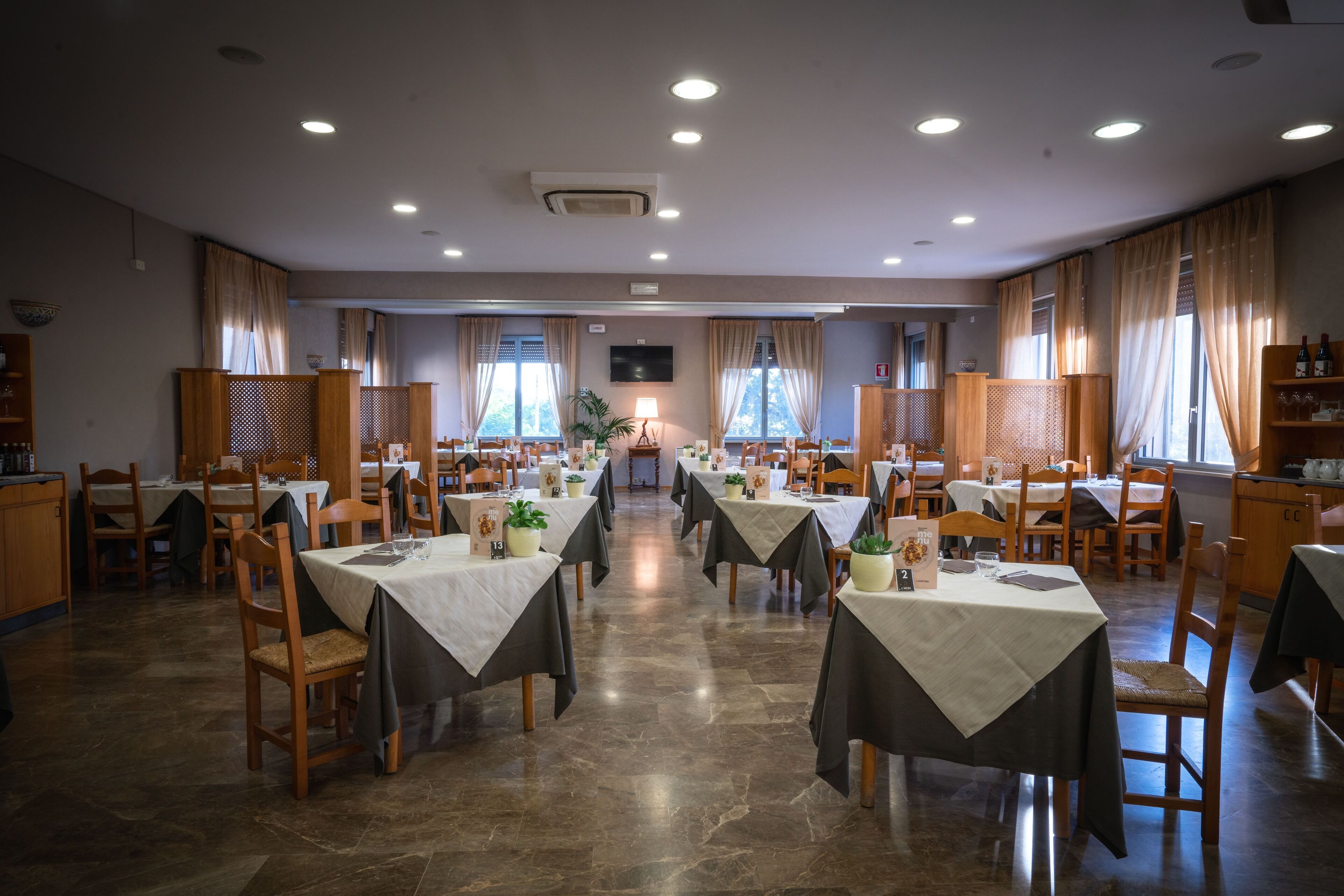 A spacious dining area with multiple tables and chairs, arranged in rows.