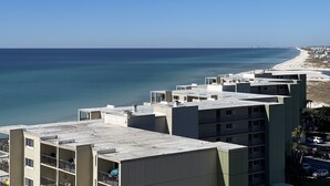 Un hotel frente al mar con varias plantas, balcones y vistas a la playa y al océano.