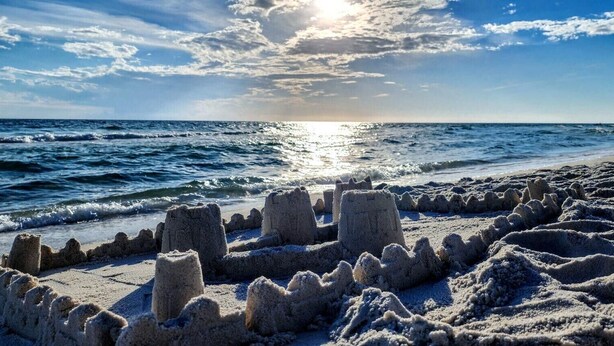 Una playa con esculturas de arena y el océano.