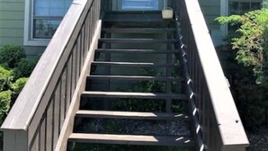 A wooden staircase leading to a house with a green exterior. - Private Waterfront Loft - an amazing lake view (Leamington)