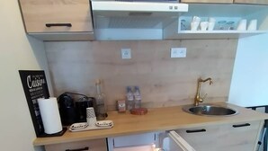 Kompakti keittokomero, jossa on sisäänrakennettu jääkaappi, pesuallas ja pieni työtaso.