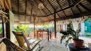 A covered outdoor seating area with wooden furniture and potted plants. - Orama Lodge Bora Bora - Le Fare  (Bora-Bora)