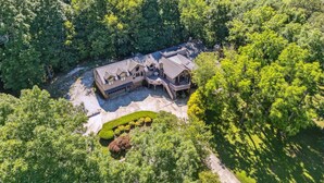 A large, two-story house with a spacious patio area and a well-maintained lawn.