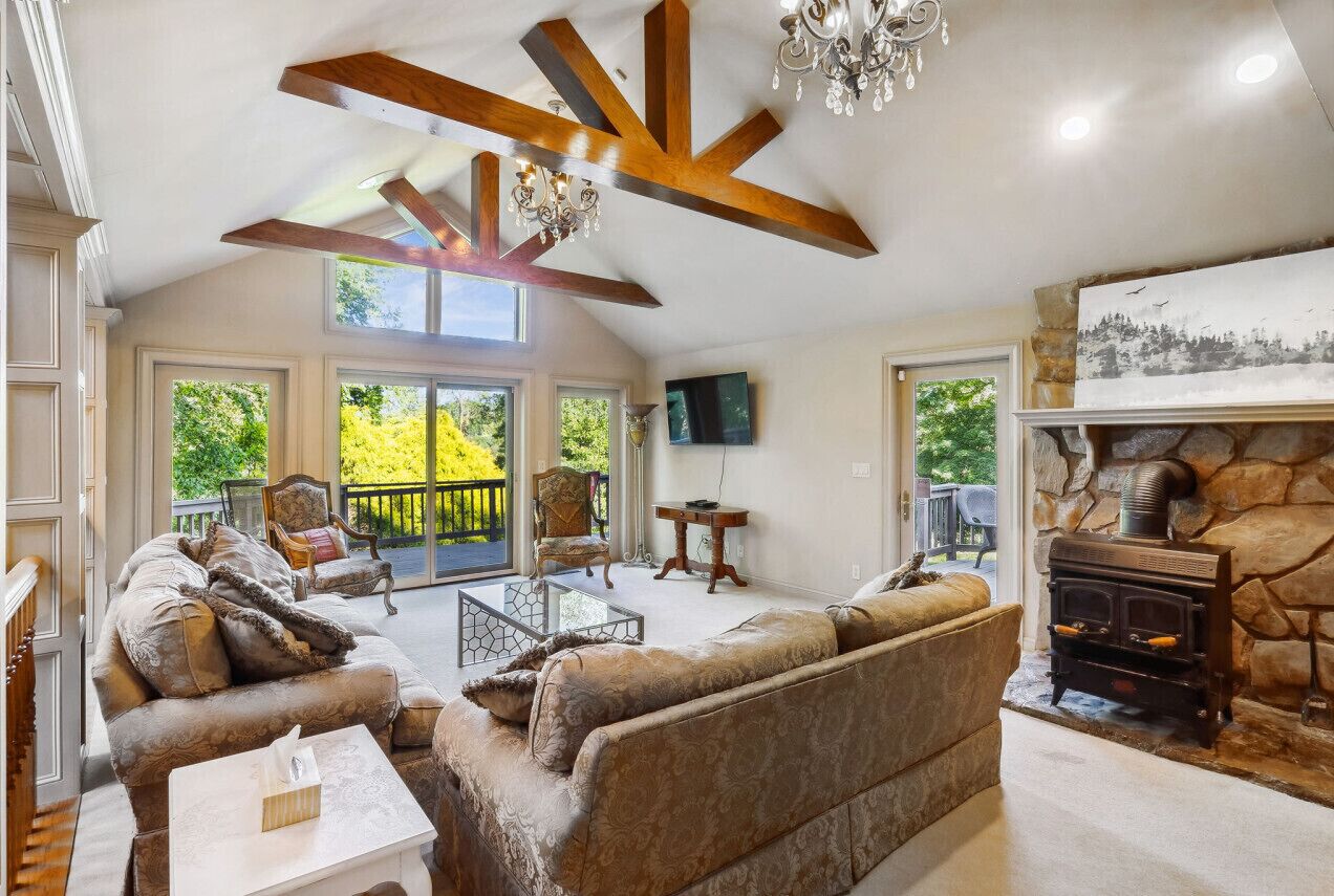 A spacious living room with a fireplace, comfortable seating, and large windows.
