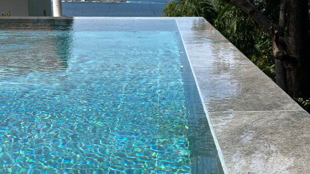 A clear infinity pool with a view of the ocean and a rocky island in the distance. - Stunning one bed/bath unit. Breathtaking ocean/jungle views with infinity pool! (Quepos)