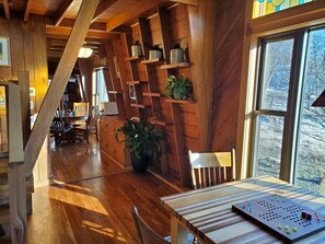 A wooden interior with a dining table, chairs, and a potted plant. - One-of-a-kind house on 245 acres w/ prairie, woods & trout-stream - pet-friendly (Hollandale)