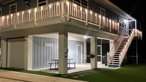 A two-story building with a balcony, a staircase, and a sign that reads "SEAS THE DAY".