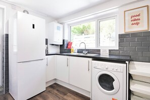Enjoy cooking in this well-equipped kitchen with a washing machine and ample natural light.